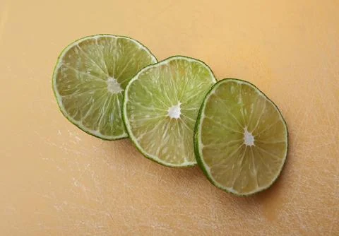 Lime slices on an orange background Stock Photos