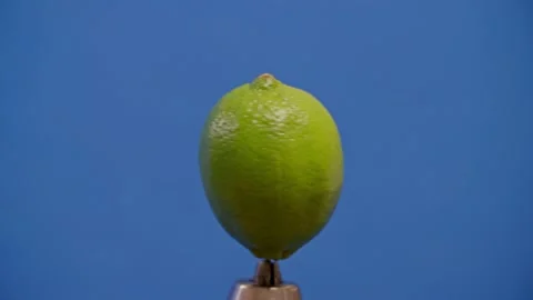 Lime spinning on blue screen 库存影片 220755805