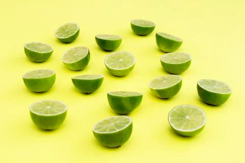 Lime split in half on a yellow background Stock Photos