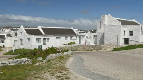 Lime washed thatch cottages artists viewpoint at Arniston fishing community Stock Footage 166896203