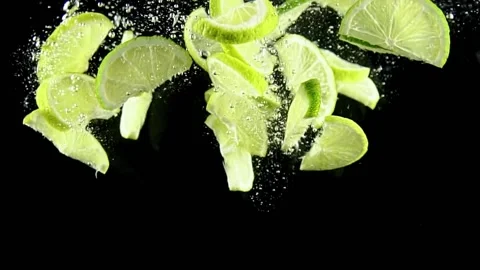 Lime wedges fall quickly into the water Stock Footage 161084059