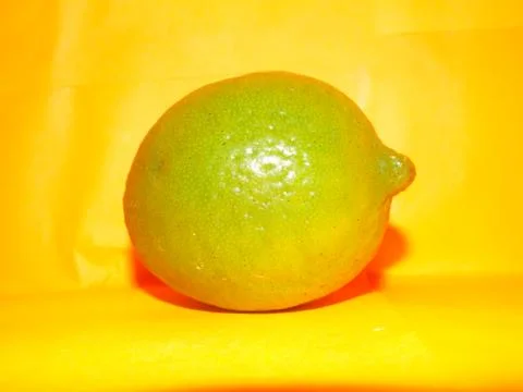 Lime on a yellow background Stock Photos
