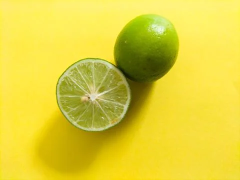 Lime on yellow background Stock Photos