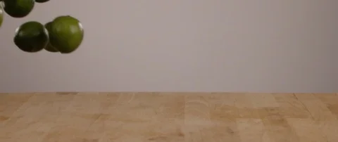 Limes Falling Onto Cutting Board In Slow Motion Vídeo Stock 105377432
