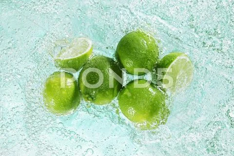 Limes in sparkling water Stock Photos