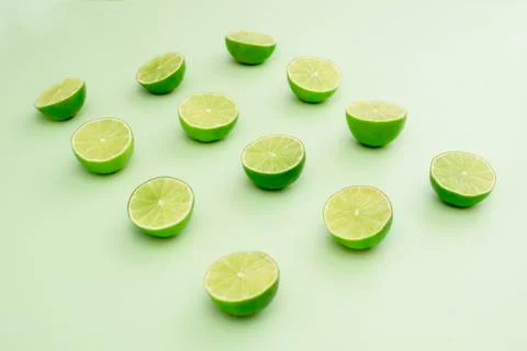 Limes split in half on a green background Stock Photos