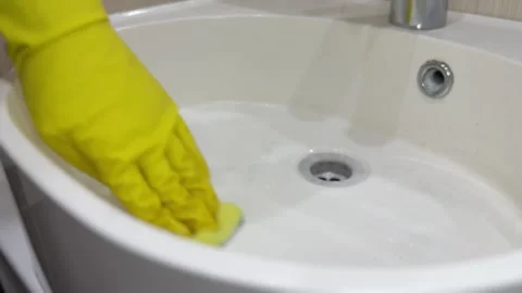 Limescale removal from sink using sponge and gloves Stock Footage 310353005