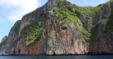 Limestone cliffs with boat off coast of Phuket, Thailand Stock Footage 58975803