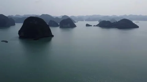 Limestone karst formations rising from emerald waters in Ha Long Bay Vietnam Stock Footage 329226164