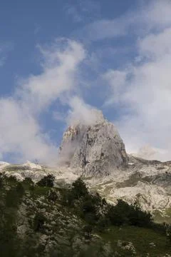 Limestone peak revolved with clouds passing by Stock Photos