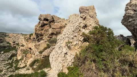 Limestone rock formations tower over a coastal footpath honeycomb weathering Видео 343679625