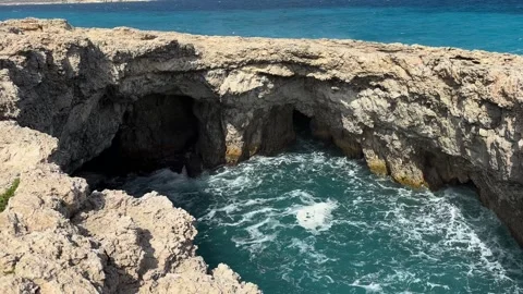Limestone sea cave arch waves crash turquoise water malta rocky cliff overhang Видео 343680861