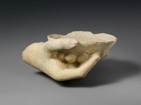 Limestone statue fragment of a right hand holding a phiale (libation bowl) .. Stock Photos