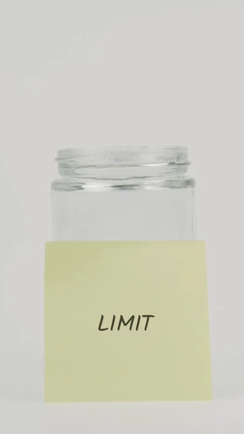 Limit text or word on yellow sticky note attached to glass jar with hand Stock Footage 311750486