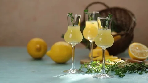 Limoncello with thyme in three grappas wineglass in wooden tray Stock Footage 118205385