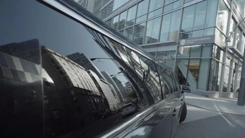Limousine making left turn with city landscape reflected in windows Stock Footage 167672736