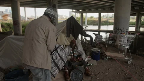Limping Homeless Man with Bag Heading towards Friend and Sitting next to Him Stock Footage 317314393
