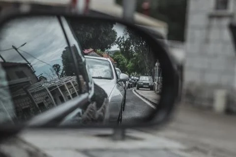 Line of Alfa Romeos lined up on an intersection, seen from a rear view mirror Stock Photos