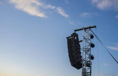 Line array speaker system hanging from pole during daylight performance Stock Photos