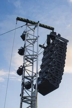 Line array speaker system hanging from pole during daylight performance Stock Photos