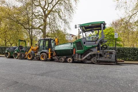 Line of asphalt paver, front loader and roller parked on city street. London, UK Stock-Fotos