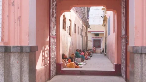 Line of beggars sitting outside a temple in India Stock Footage 77454447
