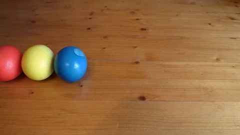 Line of bright colored easter eggs on wooden table Video stock 74577008