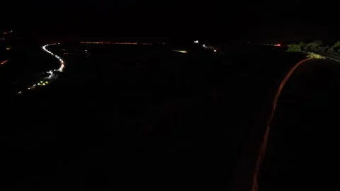 A line of car headlights driving down a steep mountain with switchbacks Stock Footage 296815133