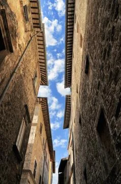 Line of cloudy blue sky bitween stone ancient biuldings in a narrow street of me Stock Photos