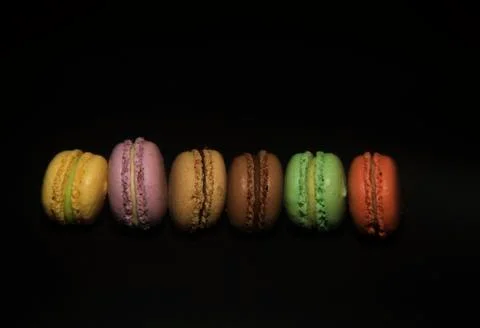 Line of colorful macaron on black background Stock Photos