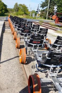 Line of empty rail bikes with orange wheels on a railroad track at the Revolu Stock Photos