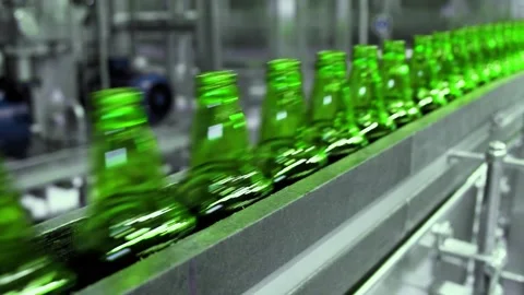 Line for filling beer in a brewery. Empty green glass bottles moving on a Stock-Footage 153933103