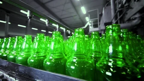 Line for filling beer in a brewery. Empty green glass bottles moving on a Stock-Footage 155012485