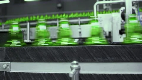 Line for filling beer in a brewery. Empty green glass bottles moving on a Stock-Footage 165495133