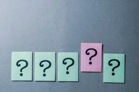 Line of five printed question marks on grey Stock Photos