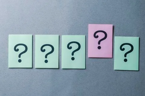 Line of five printed question marks on grey Foto stock