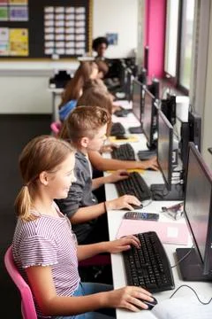 Line Of High School Students Working at Screens In Computer Class With Female Stock Photos