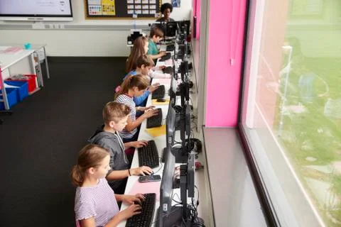 Line Of High School Students Working at Screens In Computer Class With Female Stock Photos