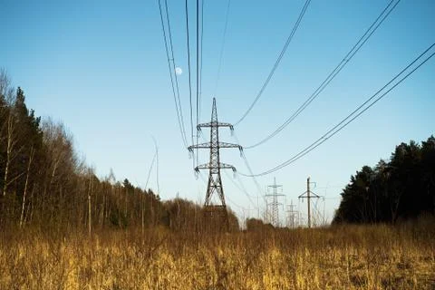 A line of high-voltage pillars through a plowed agricultural field Stock Photos