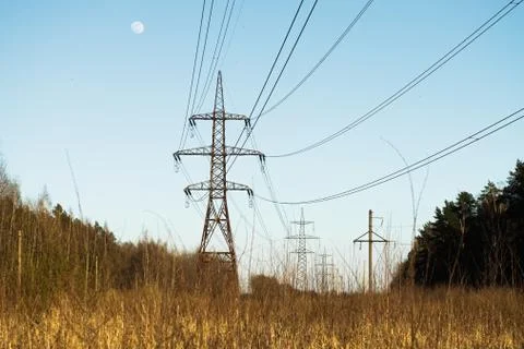 A line of high-voltage pillars through a plowed agricultural field Stock Photos