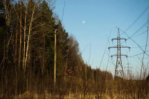 A line of high-voltage pillars through a plowed agricultural field Stock Photos