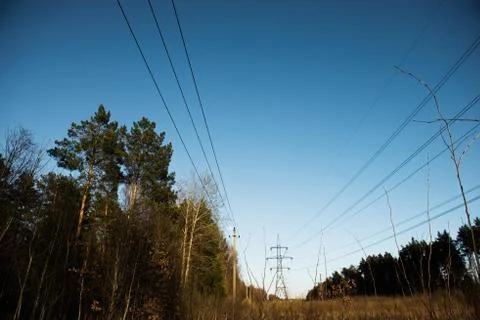 A line of high-voltage pillars through a plowed agricultural field Stock Photos