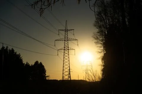 A line of high-voltage pillars through a plowed agricultural field Stock Photos