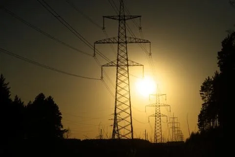 A line of high-voltage pillars through a plowed agricultural field Stock Photos