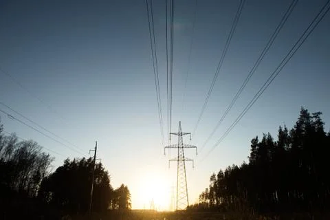 A line of high-voltage pillars through a plowed agricultural field Stock Photos