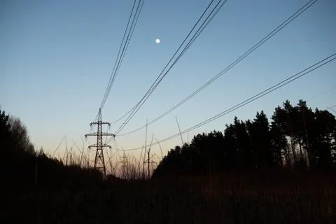 A line of high-voltage pillars through a plowed agricultural field Stock Photos