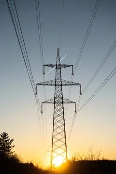 A line of high-voltage pillars through a plowed agricultural field Stock Photos