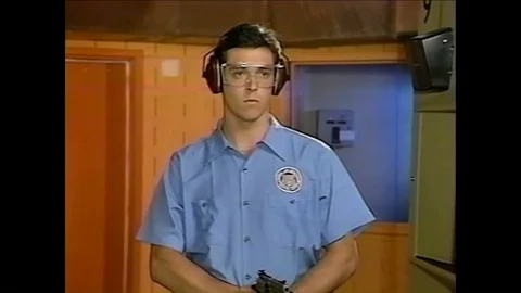 A line instructor corrects the position of a pistol and a student aims a shotgun Stock-Footage 92629865