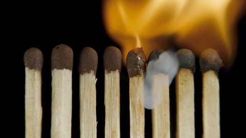 Line of lighted matches on black background Stock Footage 100585243