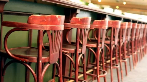 Line of many empty red bar retro wooden chairs stools outside with sun day light 스톡 동영상 117111063